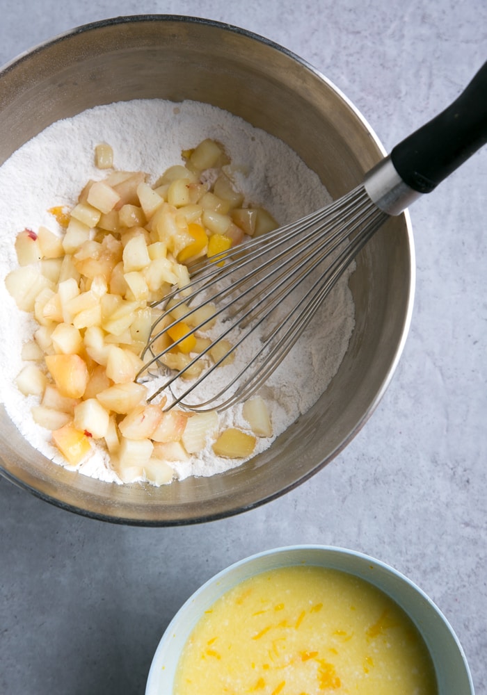 bowl with flour mixture, whisk and chopped peaches and another small bowl with egg mixture