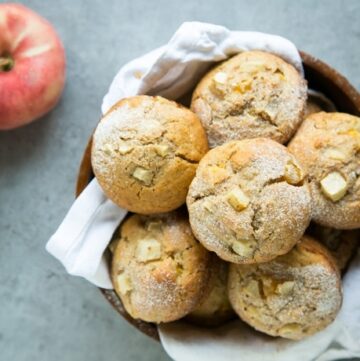 peach muffins in a bowl and 2 peaches on the background