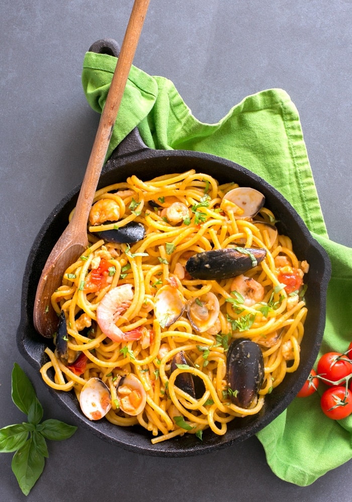 The easiest Seafood Fresh Pasta recipe, made with clams, mussels, squid and shrimp in a creamy and rich tomato sauce. A quick and delicious dinner that you can whip up in less than 20 mins! Recipe by The Petite Cook