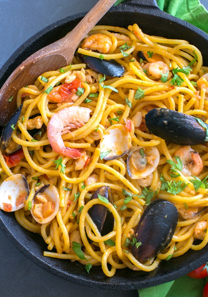 The easiest Seafood Fresh Pasta recipe, made with clams, mussels, squid and shrimp in a creamy and rich tomato sauce. A quick and delicious dinner that you can whip up in less than 20 mins! Recipe by The Petite Cook