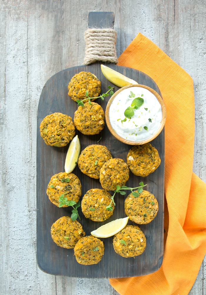 baked sweet potato and veggie fritters on a wood board