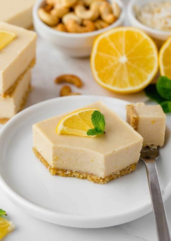 vegan lemon bar topped with lemon slice and mint leaves.