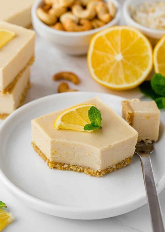 vegan lemon bar topped with lemon slice and mint leaves.