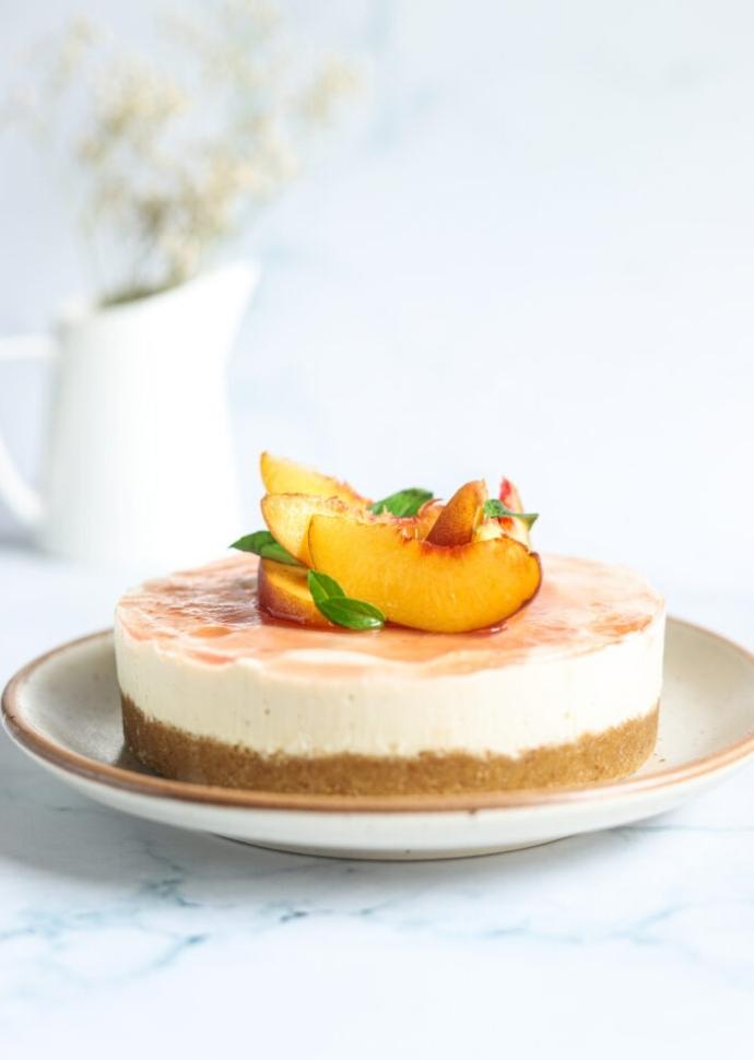 vegan no-bake cheesecake topped with peaches.