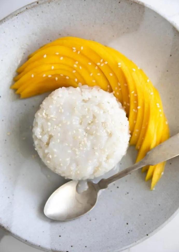 thai sticky rice served with freshly sliced mango on the side.