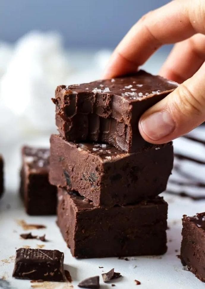 hand holding vegan chocolate fudge chunks.