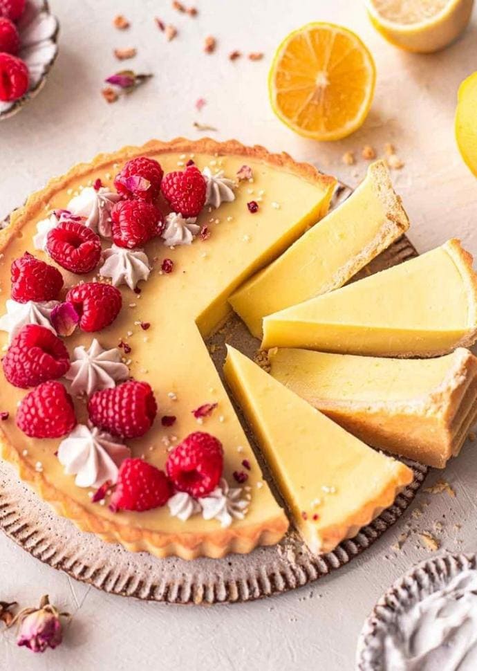 vegan lemon tart topped with raspberries.