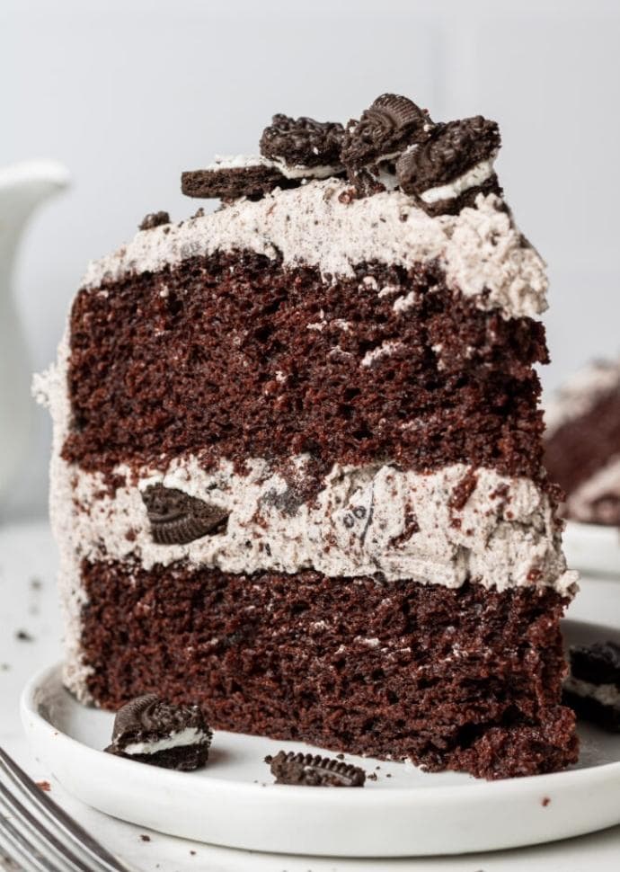 slice of vegan oreo cake with oreo buttercream frosting.