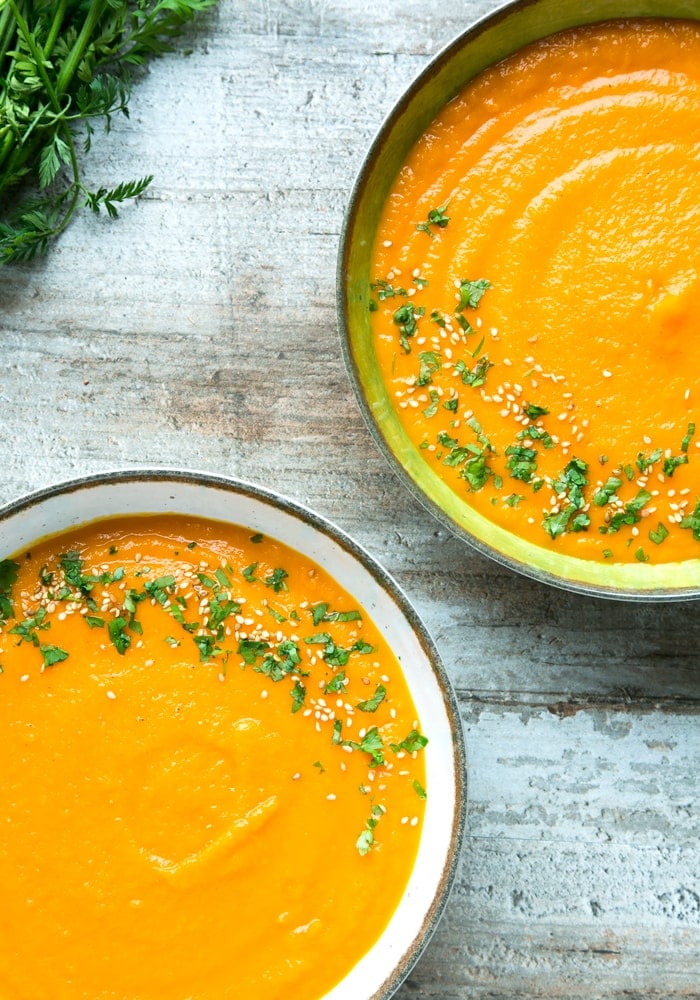 carrot and ginger soup divided among two bowls.