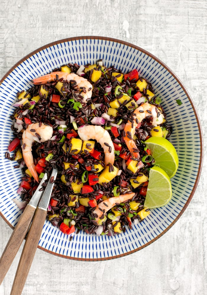 venere black rice salad with shrimps and mango salsa in a bowl