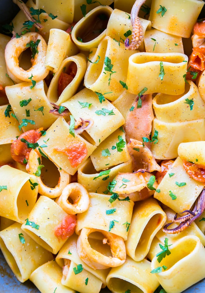 calamarata pasta with squid, tomato and chopped parsley.