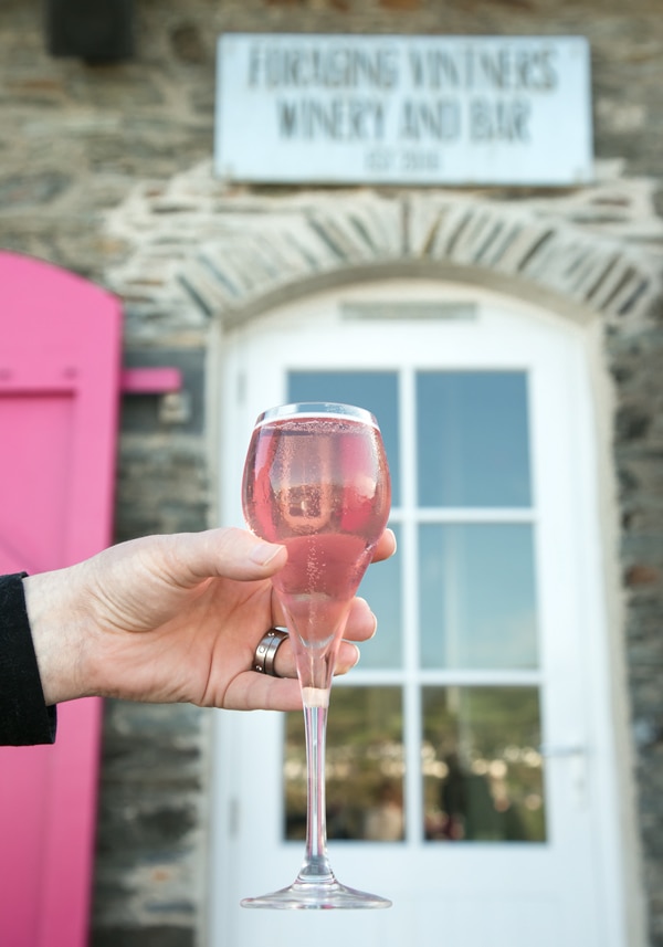 rhubarb wine in prosecco glass, winery entrance in the background