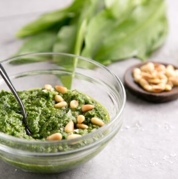 wild garlic pesto topped with pine nuts in a small glass jar