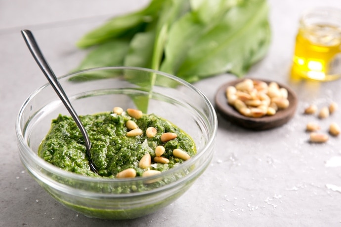 wild garlic pesto topped with pine nuts in a small glass jar