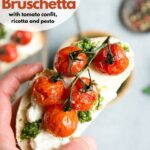 hand holding tomato confit bruschetta with ricotta and pesto, image for pinterest
