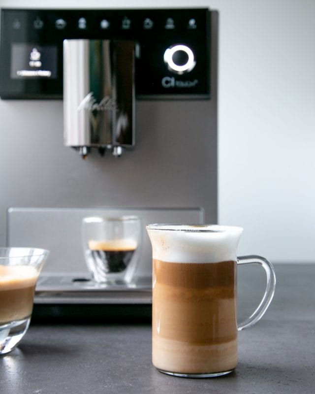 Foodie gift guide: Melitta CI Touch coffee machine , latte macchiato in clear glass cup, espresso in clear mug in the background