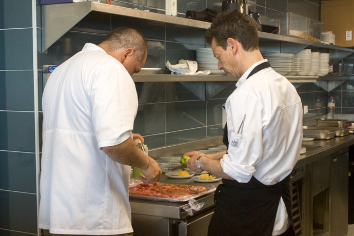 chef eduardo lalo garcia preparing food in the kitchen with kitchen staff