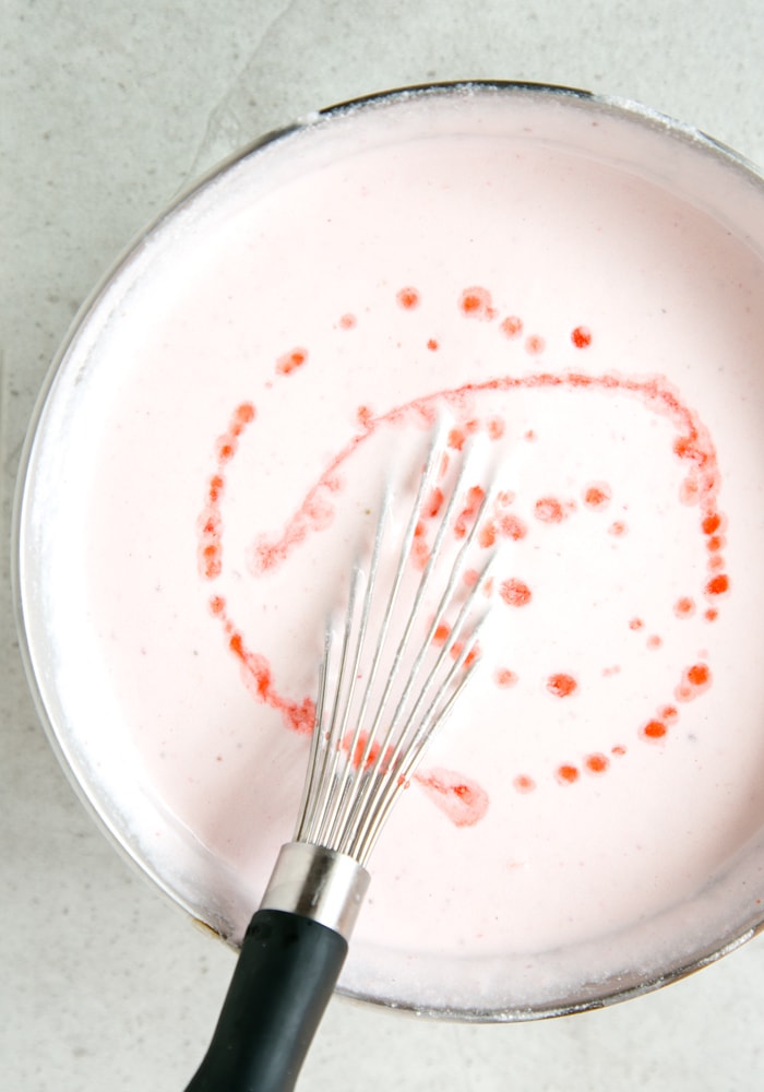 strawberry cheesecake bars filling in large meta bowl with whisk