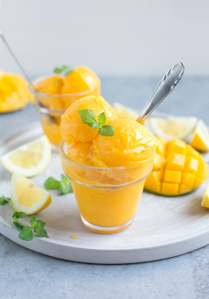 vegan mango sorbet topped with mint leaves.