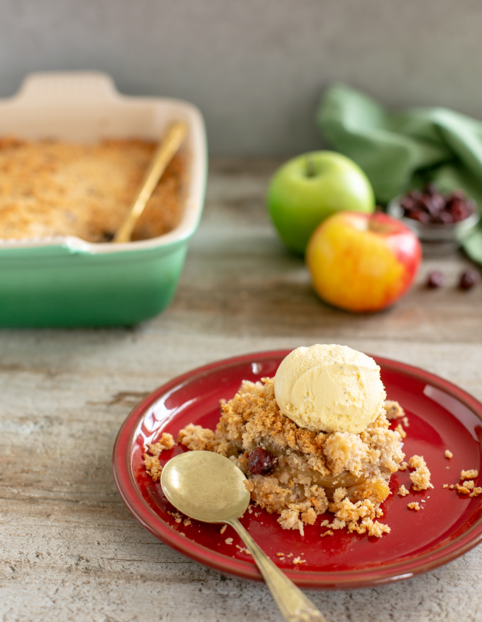 vegan apple crumble served with vanilla ice cream on top.