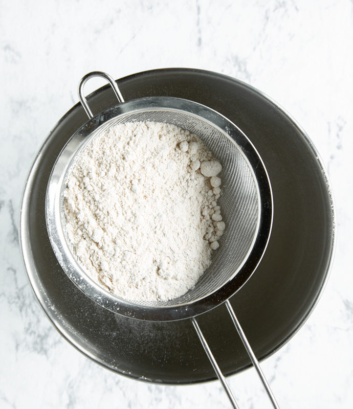 muffins recipe step 1, flour into a sifter over a metal bowl