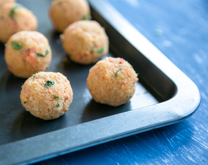 unbaked meatballs on a baking tray