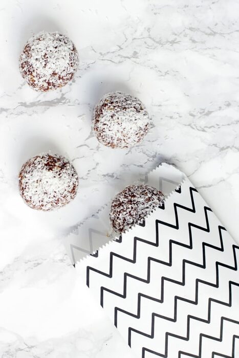 three swedish chocolate balls and a small white and black bag.