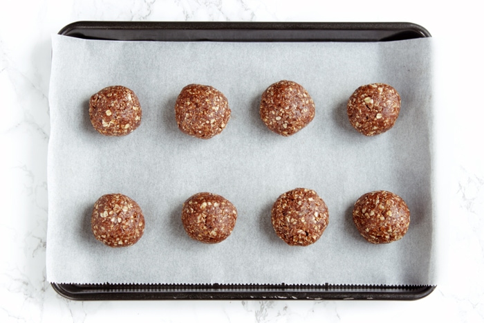 recipe step 3: mixture rolled into balls and placed on a baking tray covered with parchment paper.