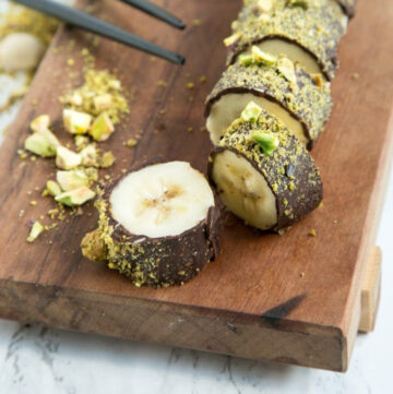 chopped chocolate covered banana sushi topped with crumbled pistachio.