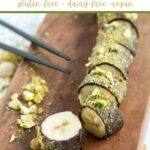 chocolate covered banana sushi topped with crumbled pistachio, chopped into bite-sized pieces. Image optimized for Pinterest.
