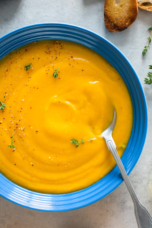 blue bowl of easy butternut squash soup with a spoon