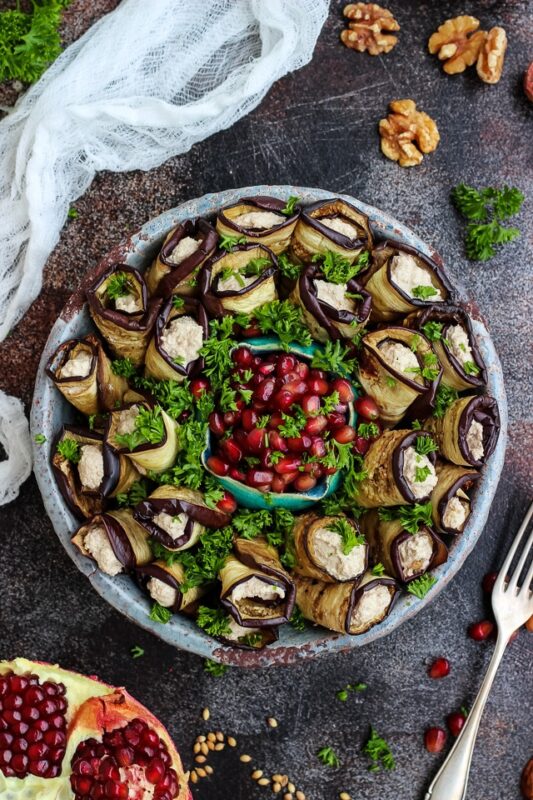 eggplant roll ups on a plate served with pomegranate