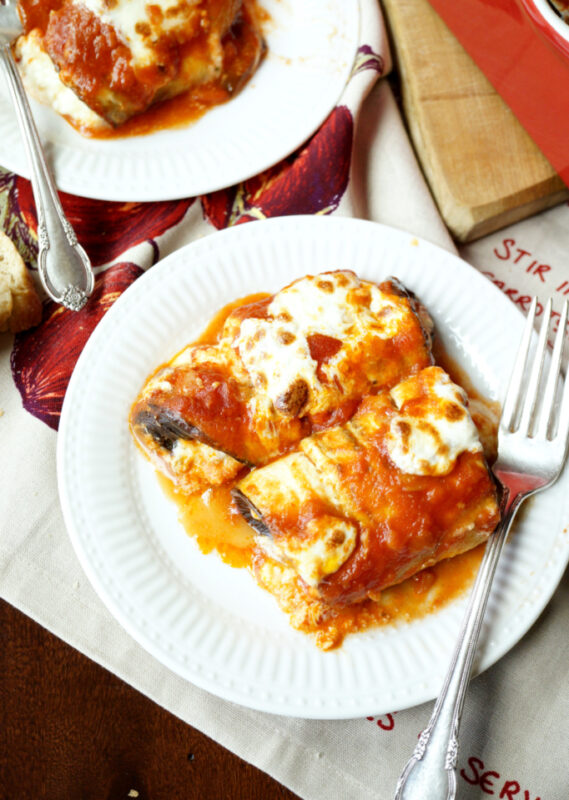 cheesy eggplant rollatini on a white plate.