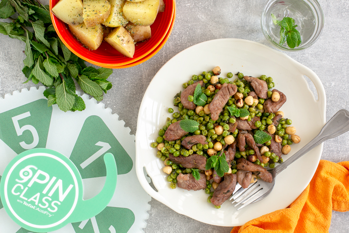 Air Fryer Mint Lamb with Toasted Hazelnut and Peas, served with roasted potatoes on the side, and spin class gear of goodness next to the dish