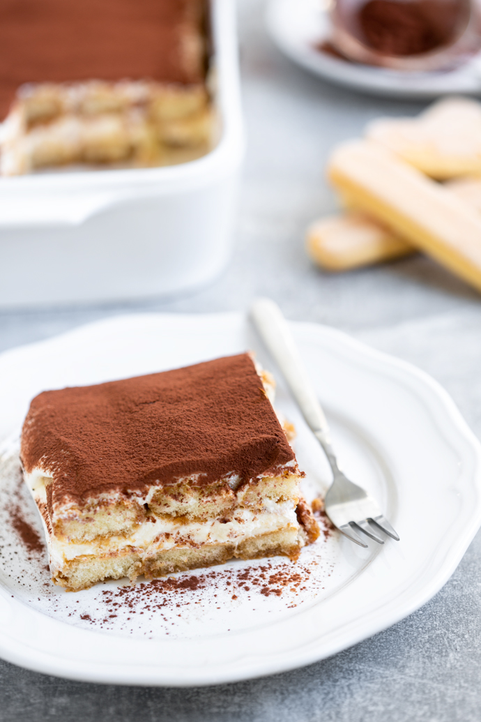 Italian Classic tiramisu without eggs served on a plate with a fork.