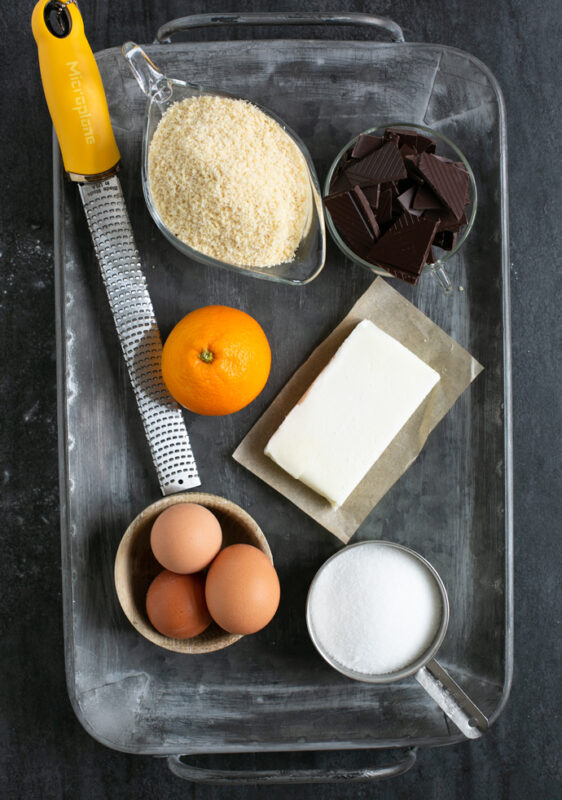 caprese cake ingredients: almond flour, chunks of dark chocolate, butter, sugar, eggs, orange zest