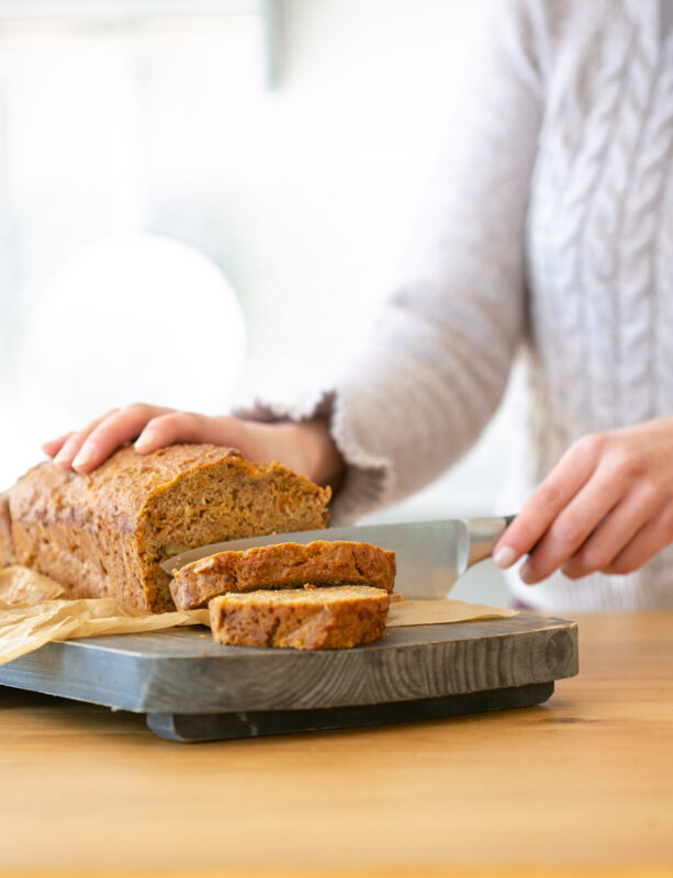 Andrea aka The Petite Cook, cutting the banana bread into slices.