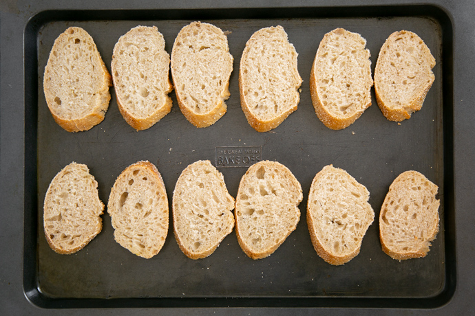 recipe step 1: sliced bread on a baking tray ready to be baked until dry and crunchy.