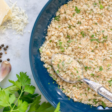 pangrattato in a large dish with a spoon.