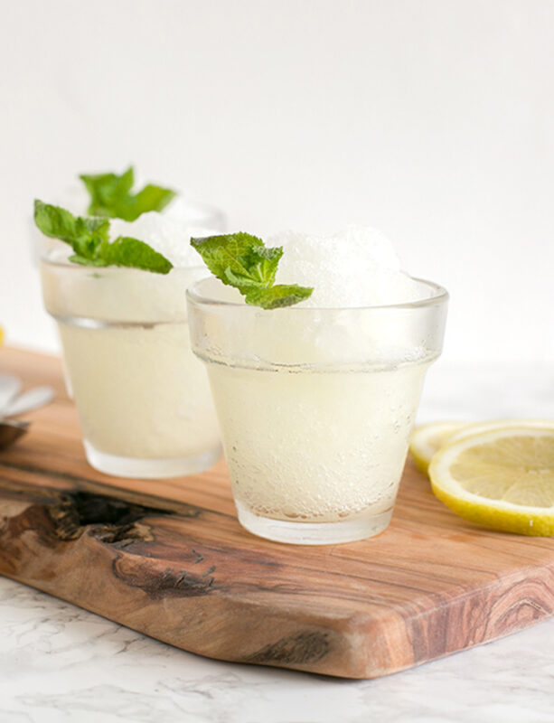two glasses with lemon granita, topped with mint leaves