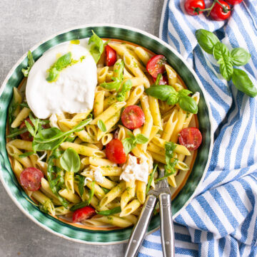 burrata pasta salad served in a big bowl with serving spoons.