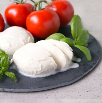 homemade mozzarella balls served with tomatoes and basil leaves.