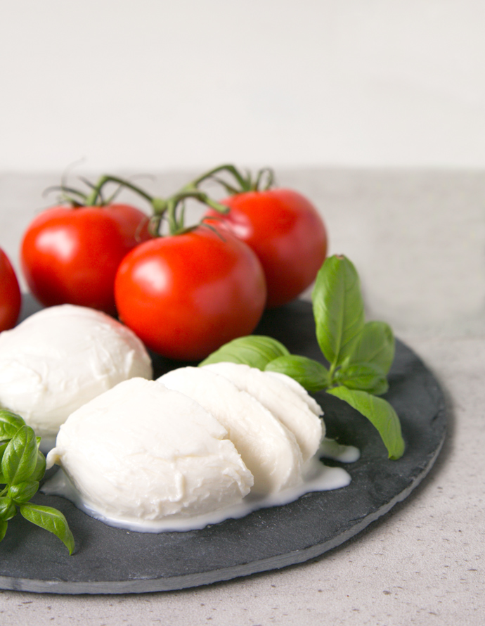 homemade mozzarella balls served with tomatoes and basil leaves.