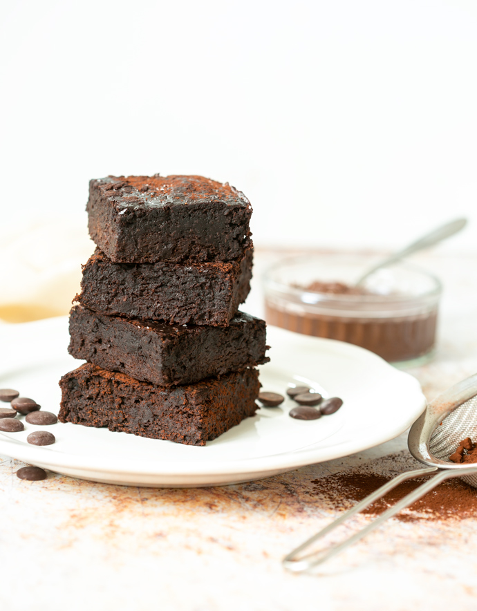 4 3-ingredient brownies on top of each other on a plate.