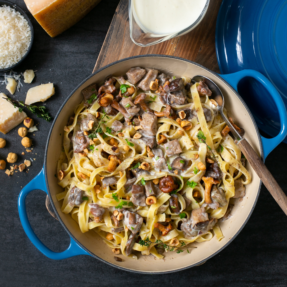 parmesan pasta with parmesan sauce, wild mushrooms and roasted hazelnuts, in a large cast iron shallow pot. Served with grated parmesan and sauce on the side.