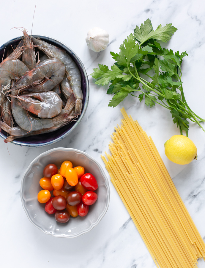 prawn pasta recipe ingredients: raw unpeeled king prawns, cherry tomatoes, garlic, bunch of parsley, lemon, linguine pasta.