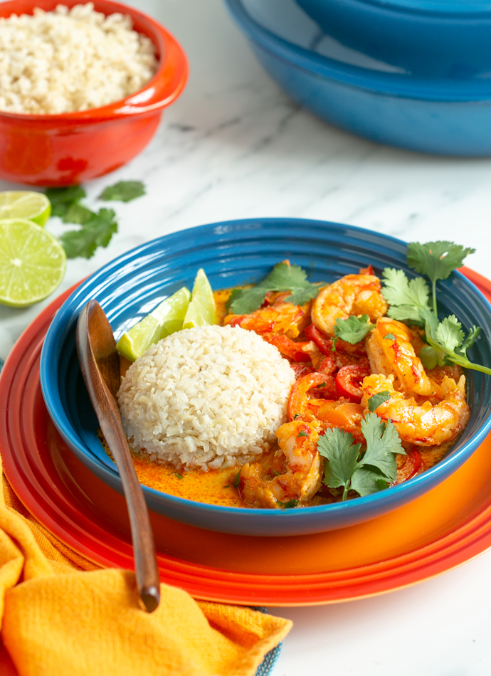 thei prawn curry served with brown basmati rice in a shallow plate.