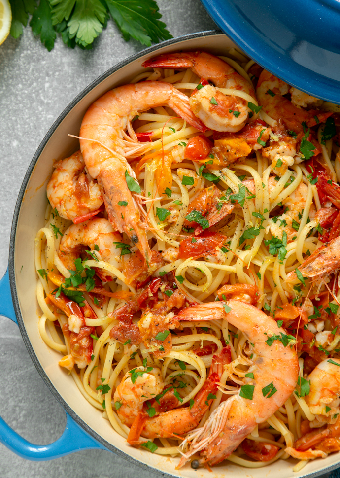 shrimp linguine topped with freshly chopped parsley in a large shallow pot.