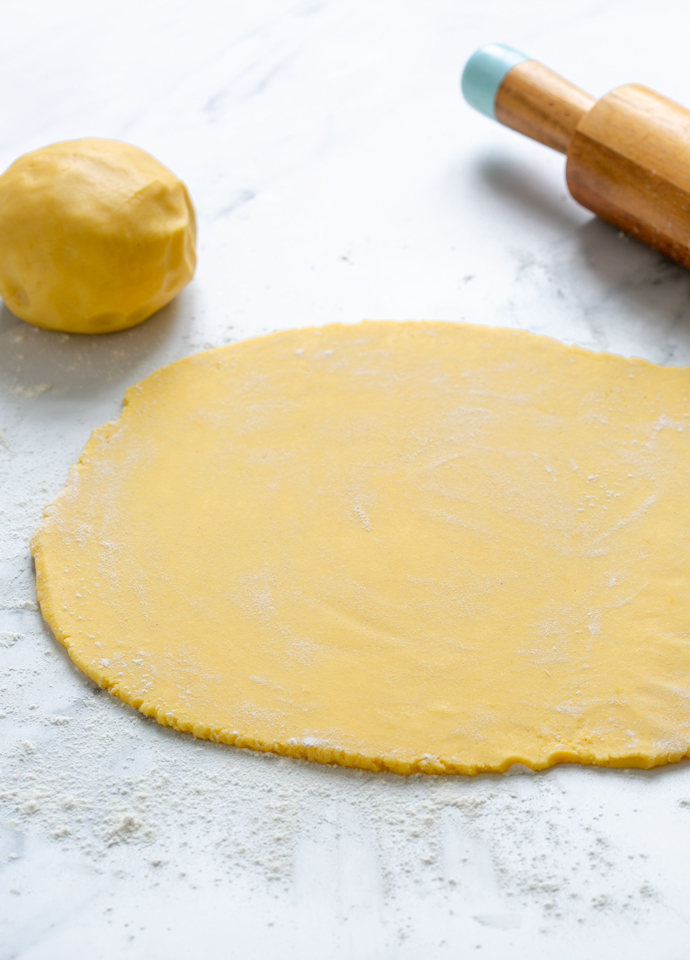 Pasta frolla rolled onto a clean lightly dusted with flour working surface.