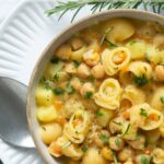 pasta and chickpea soup topped with chopped rosemary in a bowl. Image with headings for Pinterest.